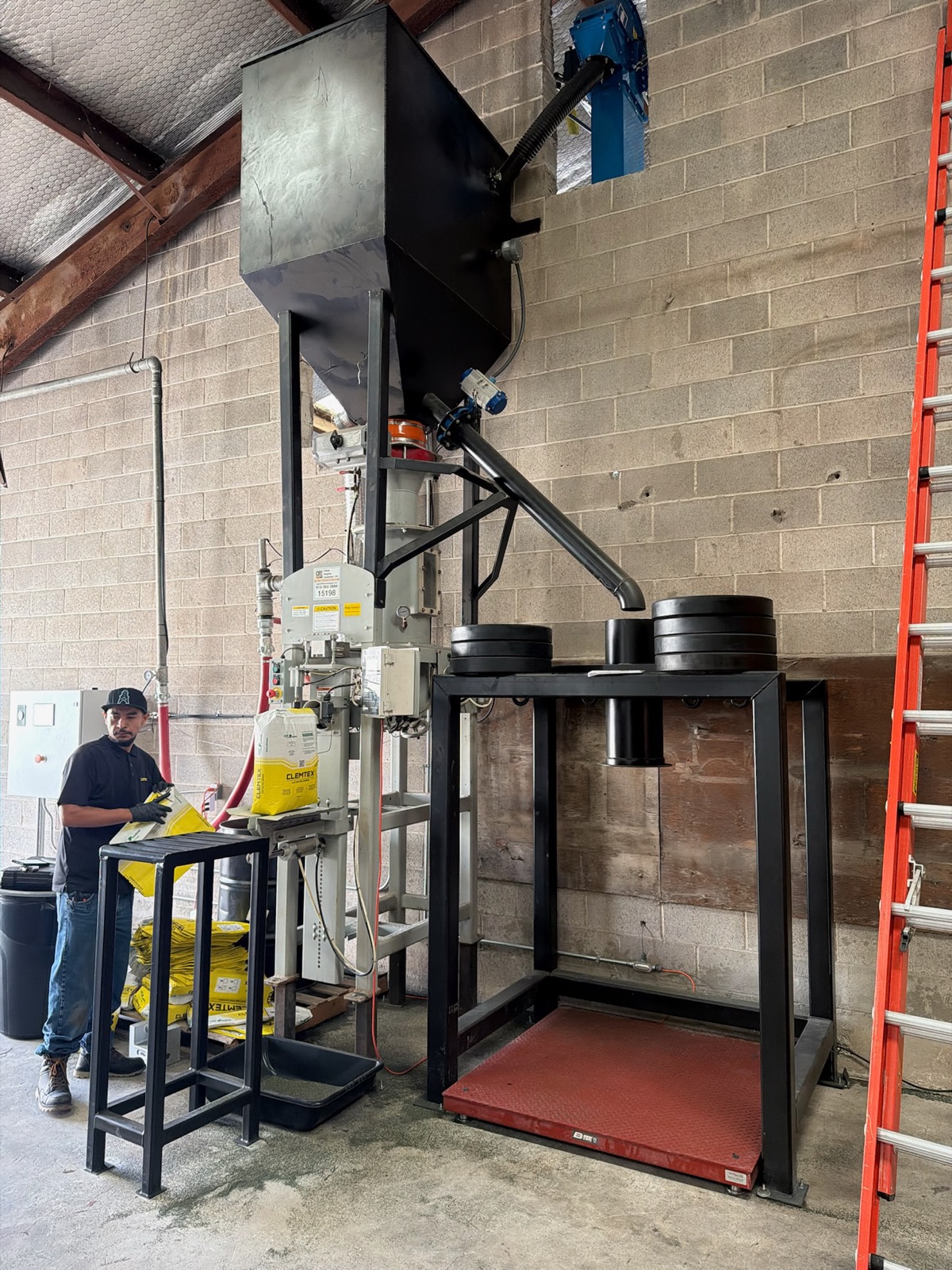 Bag fill station under a weigh hopper with a platform scale